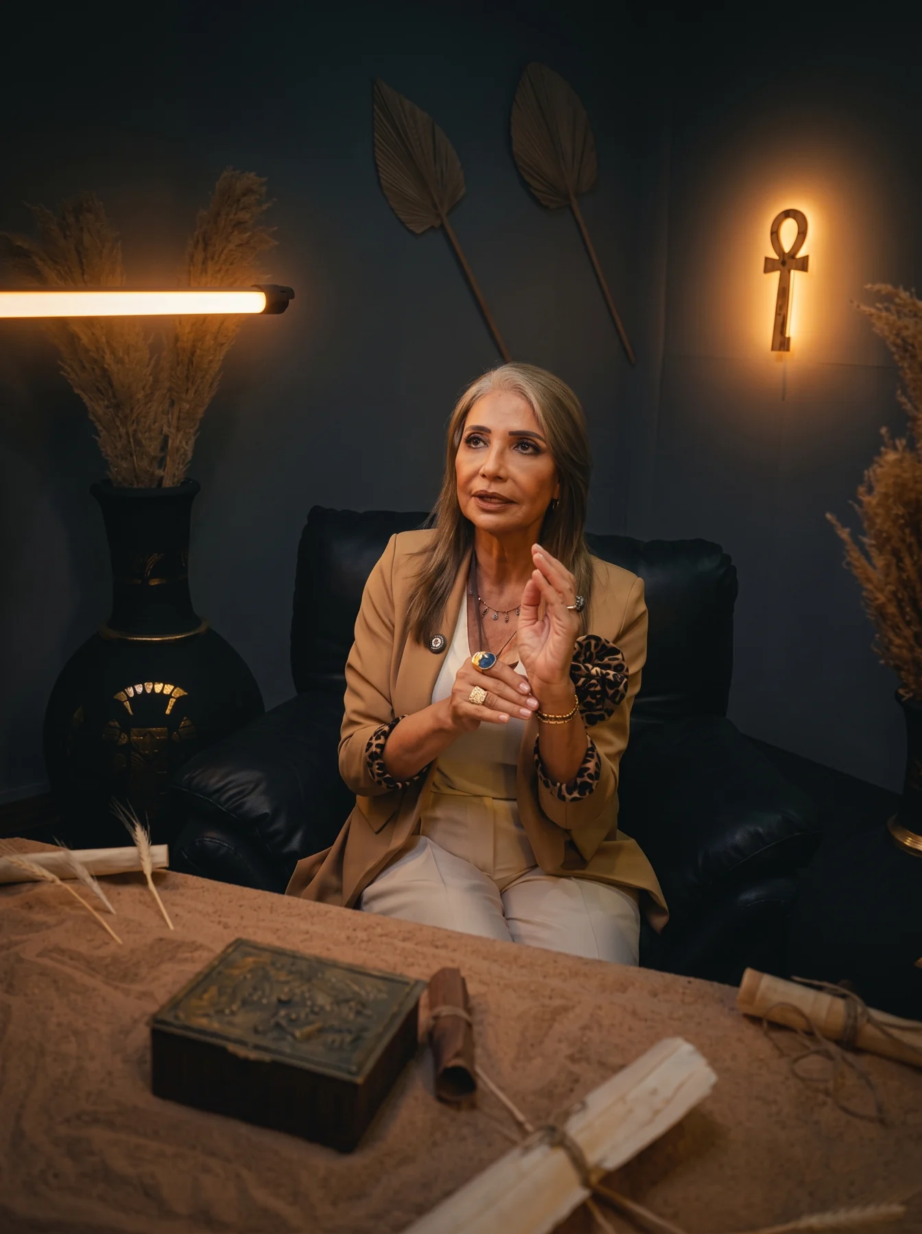A seated woman in a warm Egyptian-inspired environment