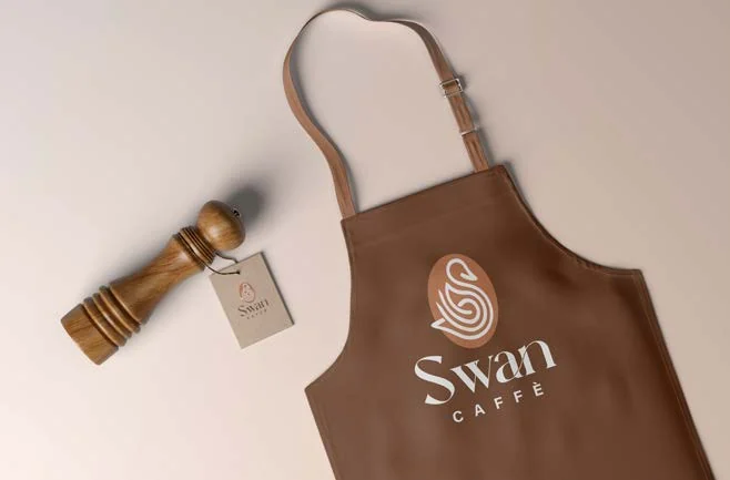 Brown Swan Café apron with a white emblem